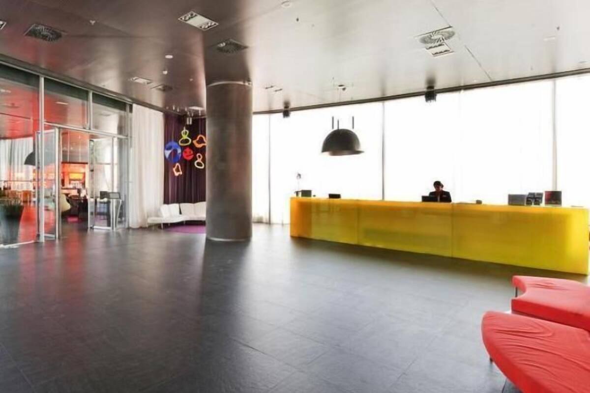 A spacious lobby with a reception desk, seating area, and large windows.