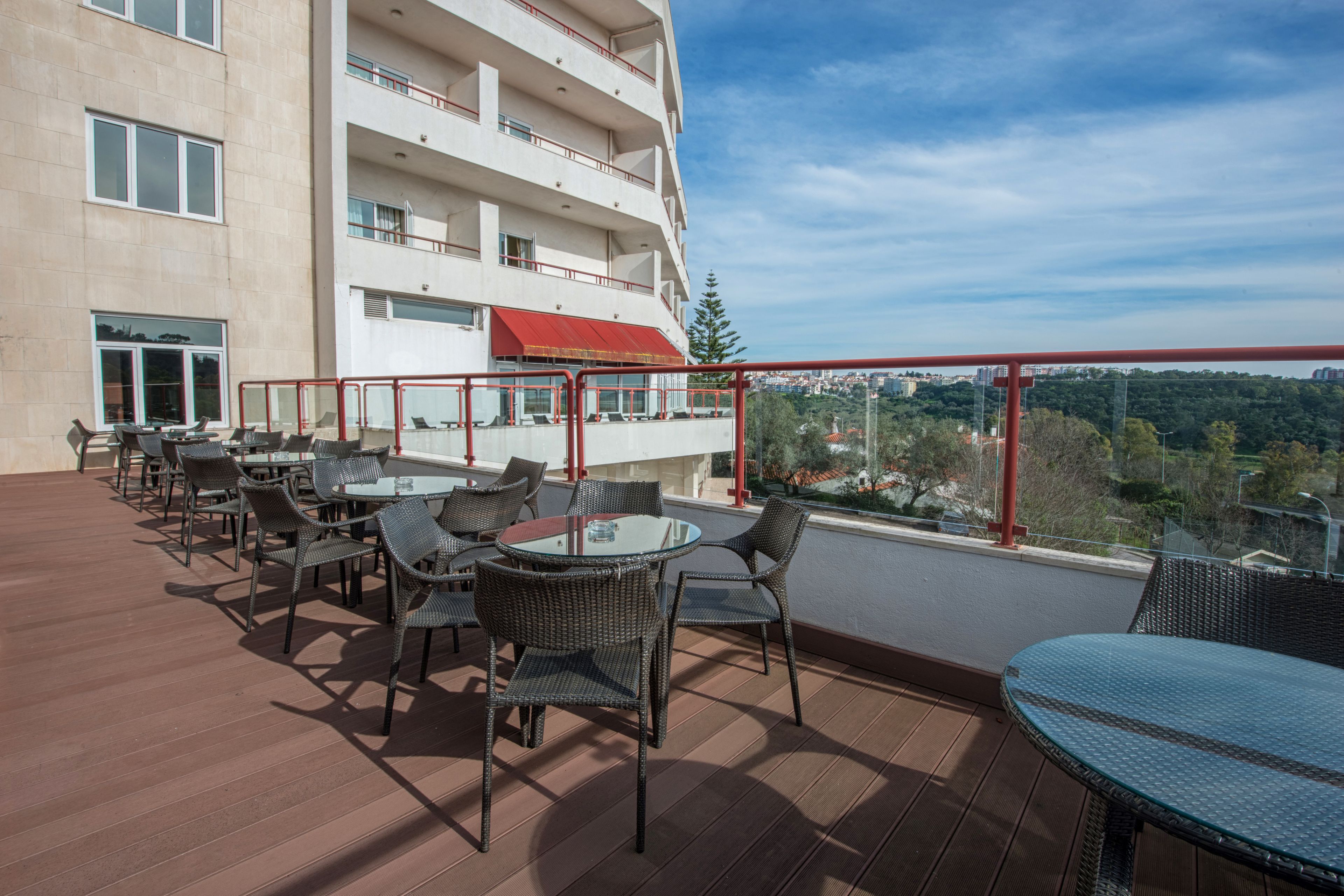 Une terrasse sur le toit avec des sièges extérieurs, une vue sur la ville et un immeuble doté de nombreux balcons.