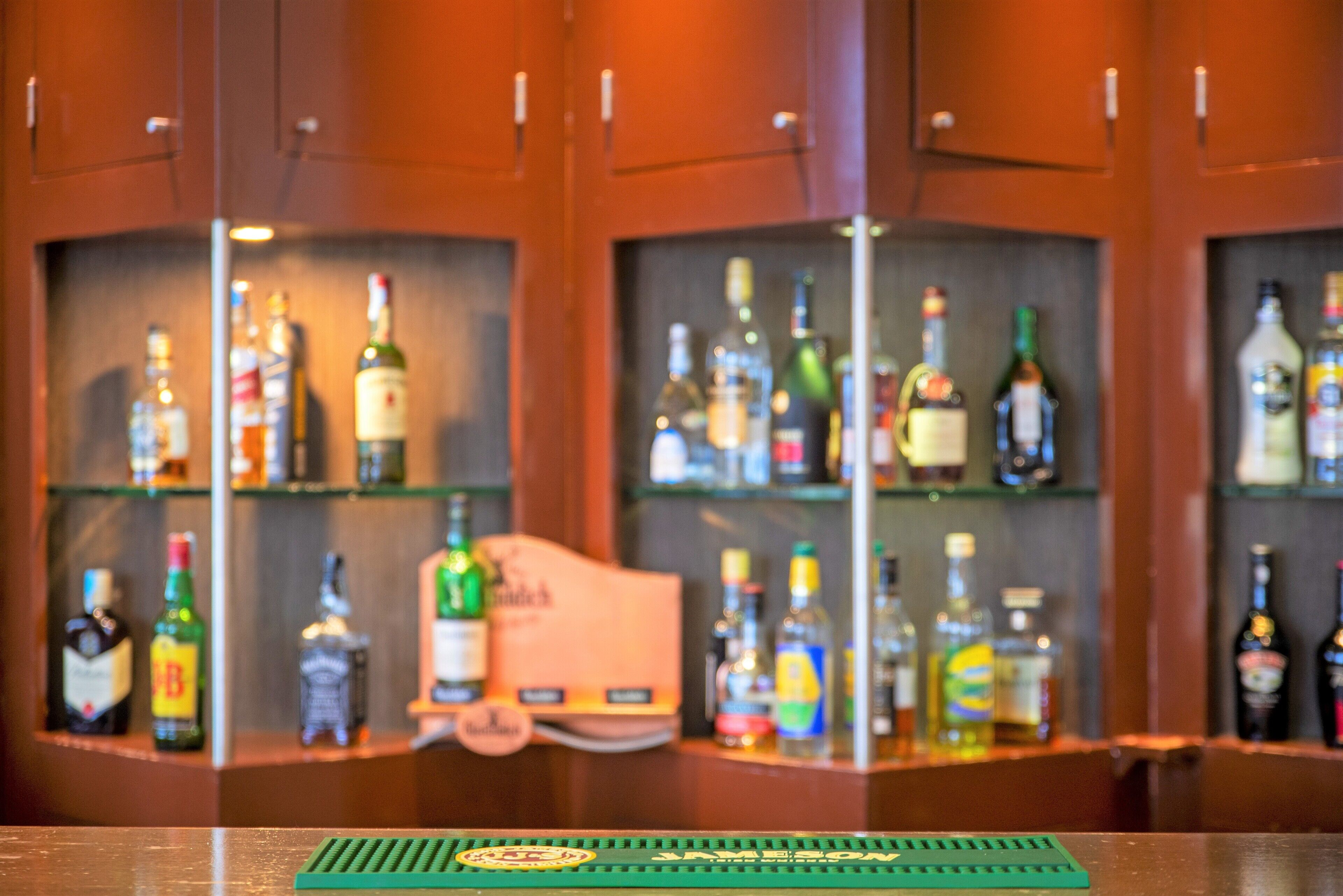 Zona de bar con estantes llenos de botellas de licores.