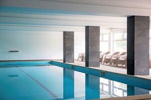 Una piscina cubierta, una piscina al aire libre de temporada, sombrillas