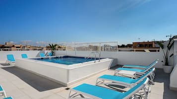 Una piscina al aire libre de temporada, sillones reclinables de piscina
