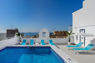 Una piscina al aire libre de temporada, sillones reclinables de piscina