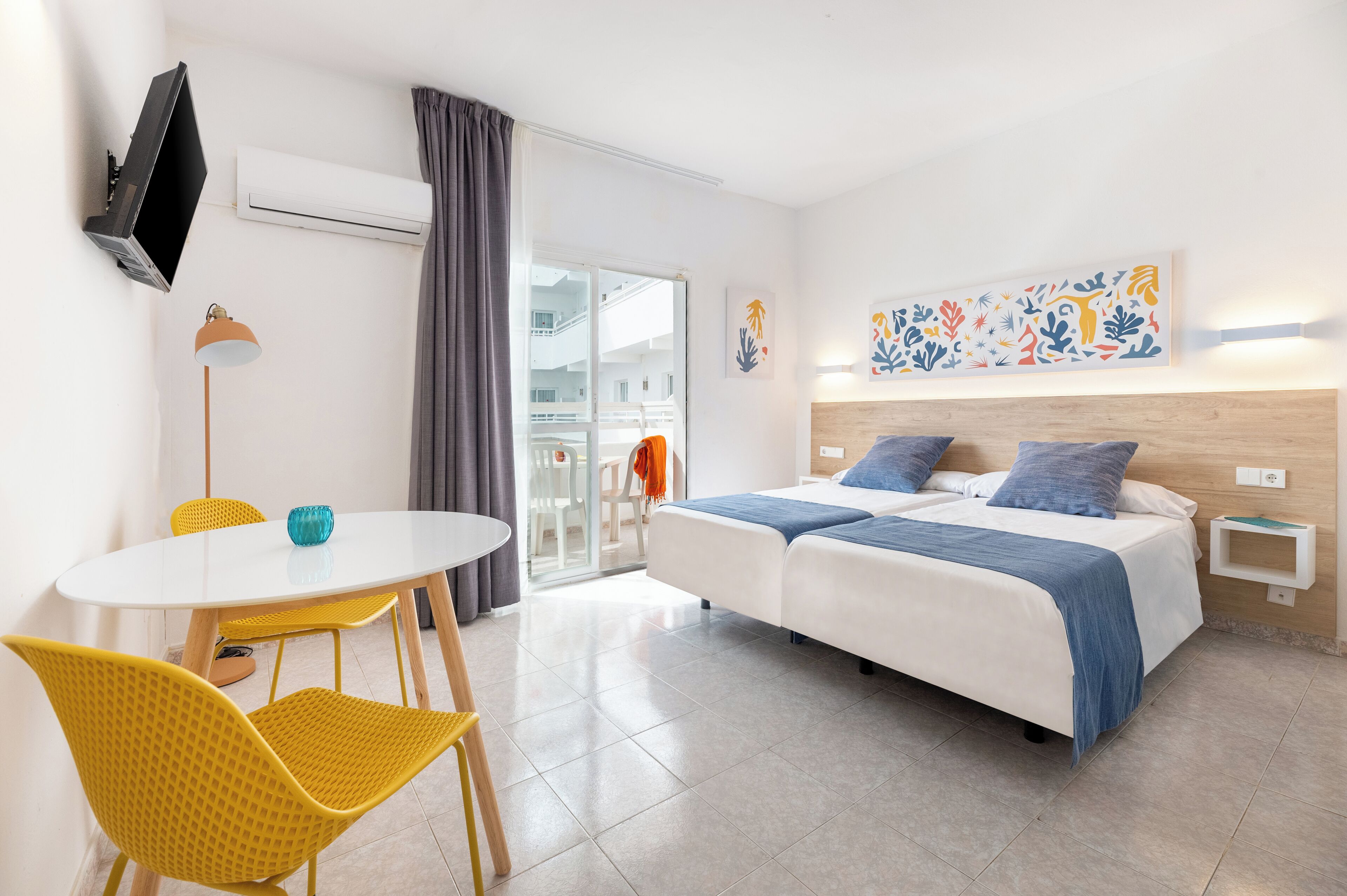 Een hotelkamer met een bed, een bureau, stoelen en een televisie.