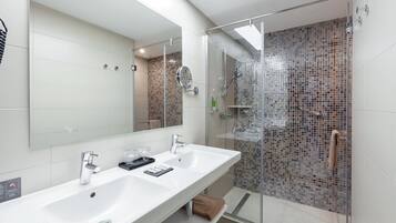 Een moderne badkamer met een groot wit wastafelmeubel, een spiegel en een douchecabine met glazen wanden.