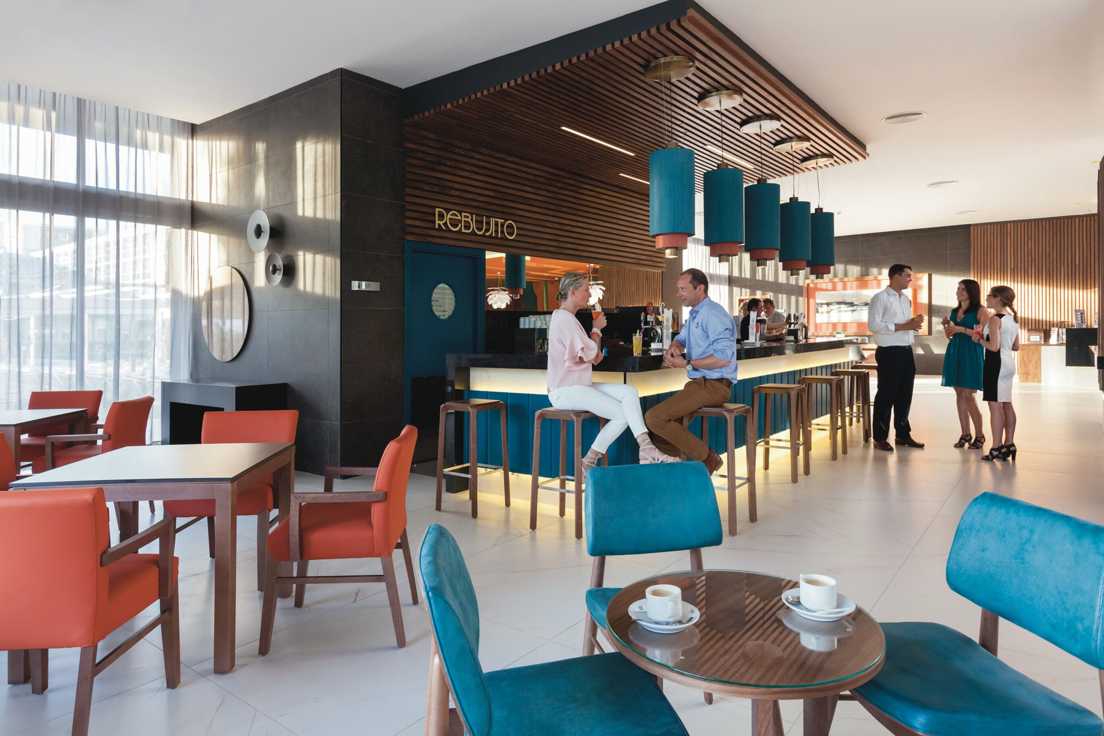 Un café moderno con barra, asientos y mostrador a la vista.
