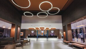 A spacious lobby with a reception desk, seating area, and modern lighting fixtures. - Hotel Riu Costa del Sol - All Inclusive (Torremolinos)