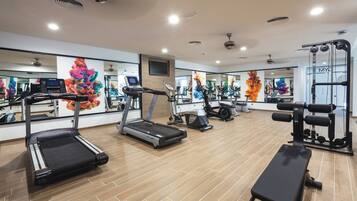 A modern gym with treadmills, a bench, and weight machines.