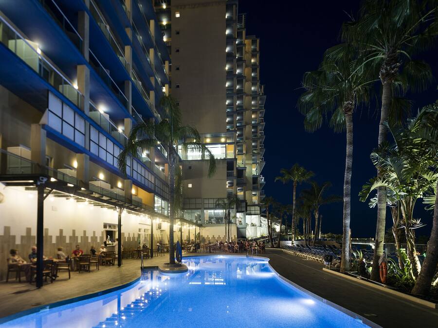 Una piscina al aire libre, sombrillas, tumbonas