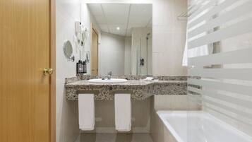 Un baño moderno con puerta de madera, un lavabo con dos espejos, ducha y bañera.