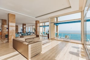 Un hall d’entrée spacieux, doté d’un coin salon, de grandes fenêtres et offrant une vue sur la mer.
