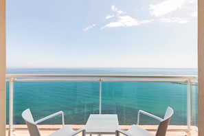 A balcony with a clear view of the ocean, two white chairs, and a small table. - Hotel Best Benalmádena (Benalmádena)