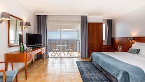 Une chambre d’hôtel comprenant un lit, une télévision, un bureau, une chaise, un balcon avec vue et une porte coulissante.