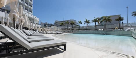 Piscine extérieure, parasols de plage, chaises longues