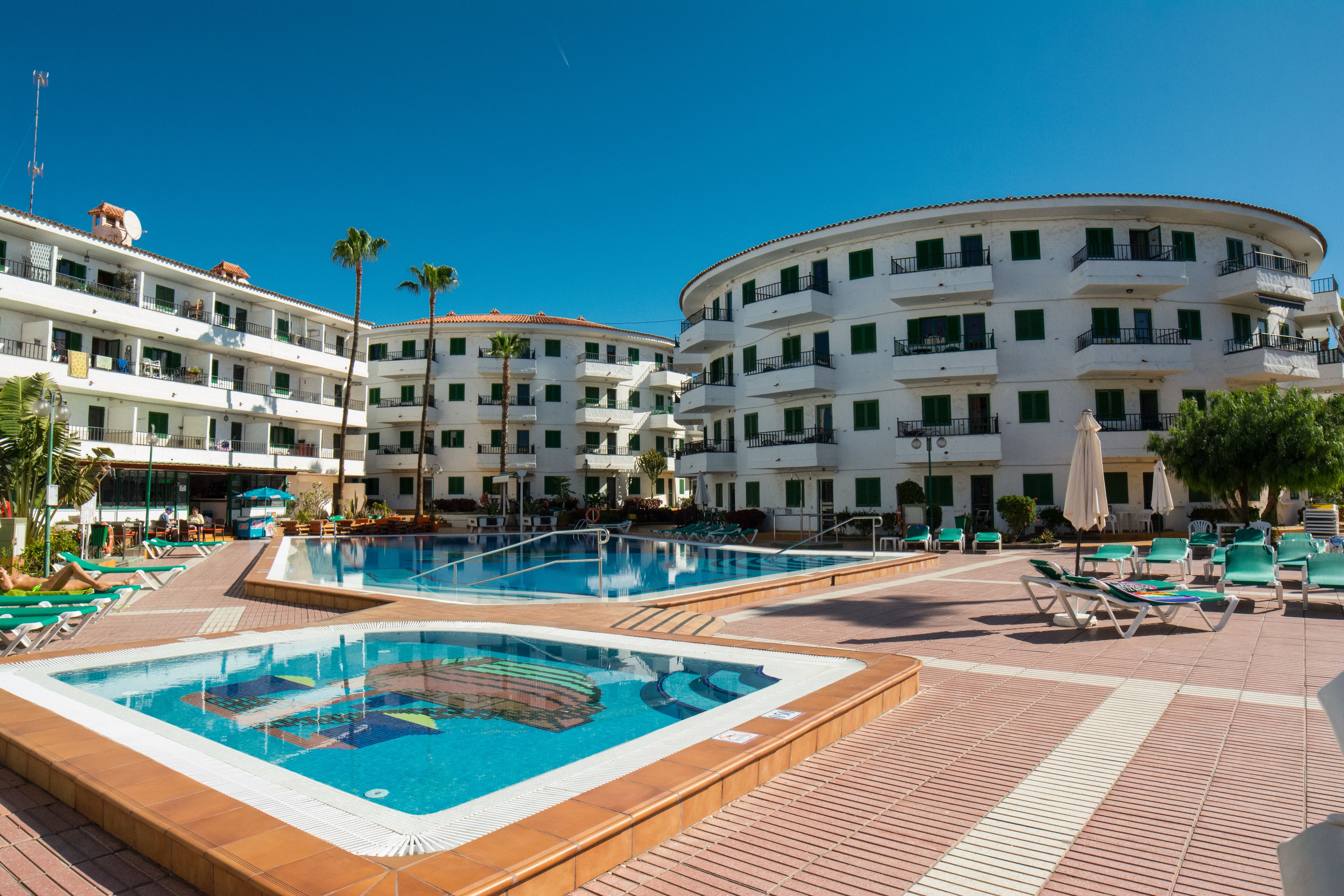 2 つの屋外プール、プール パラソル、サンラウンジャー