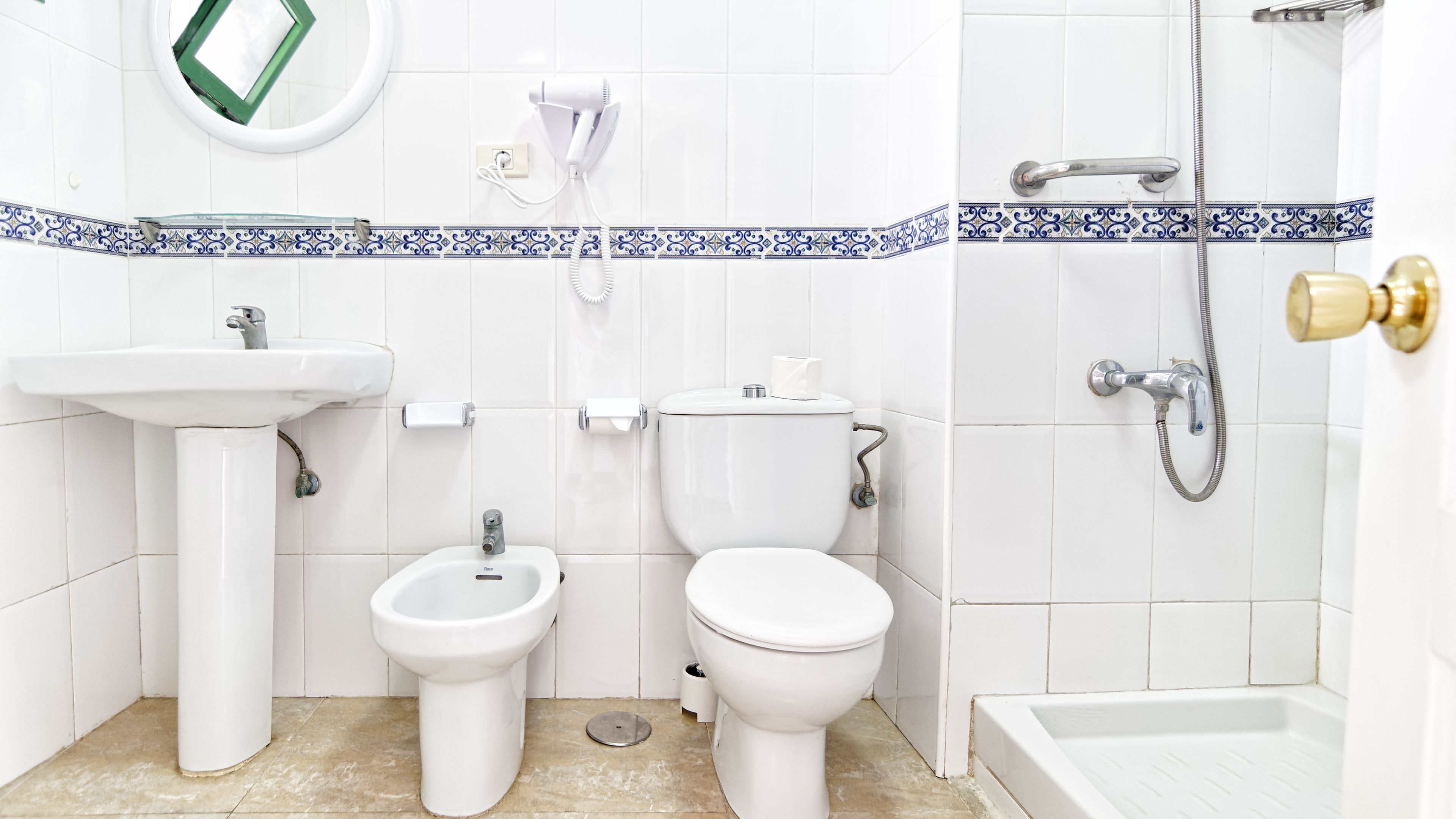 Un baño con lavamanos, bidé, inodoro y ducha.