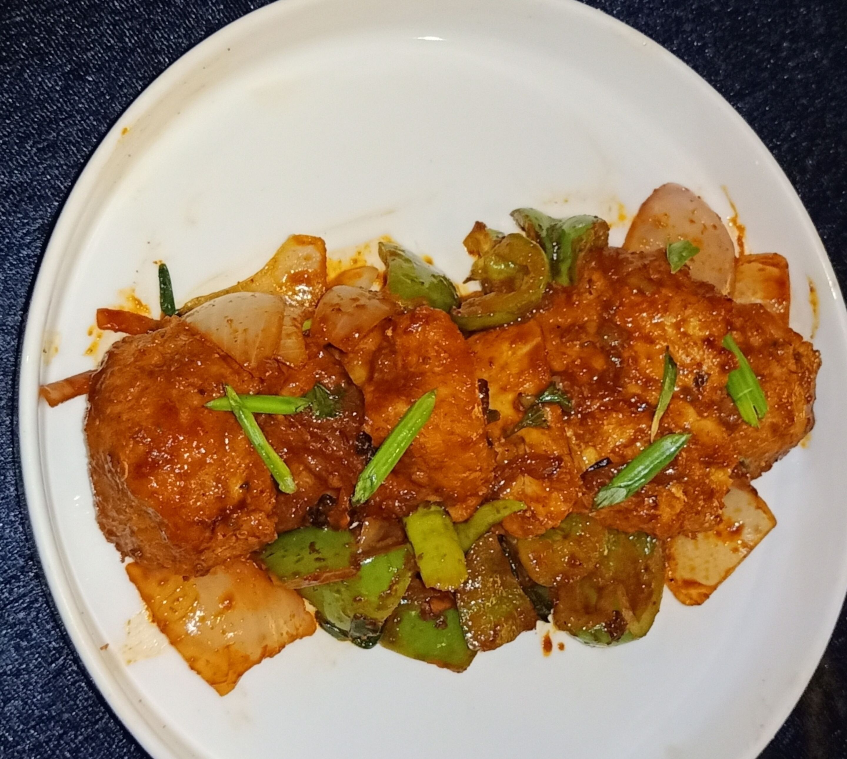 Un piatto di cibo con diversi ortaggi e salsa.
