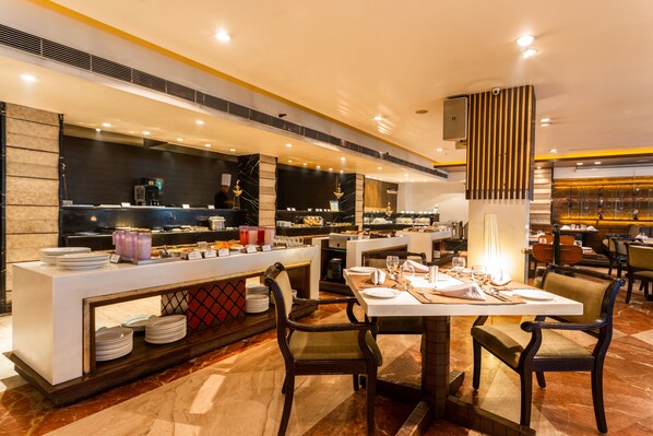 A modern restaurant with a marble counter, multiple seating options, and a well-lit interior.