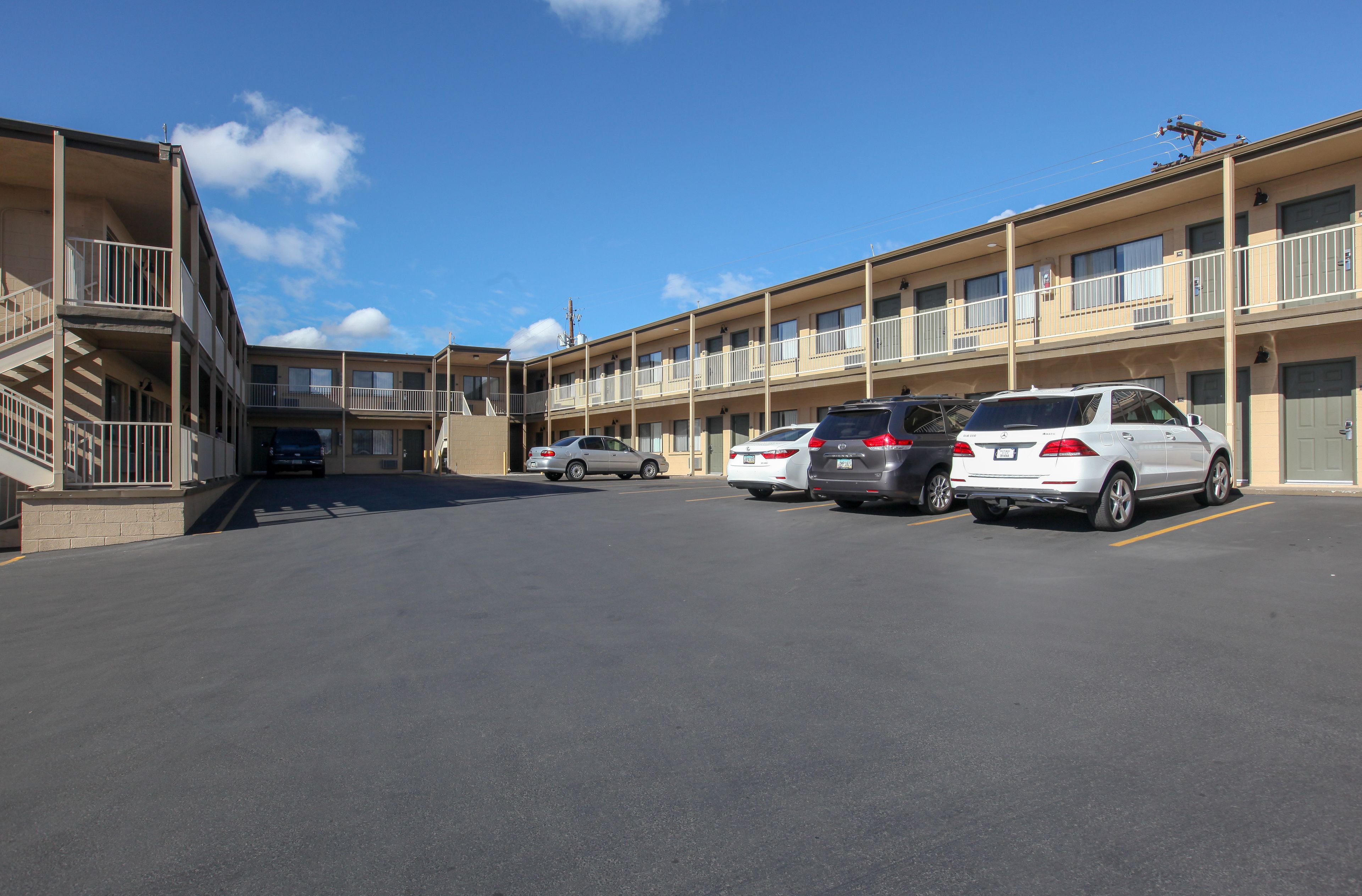 A multi-story motel with a parking lot.