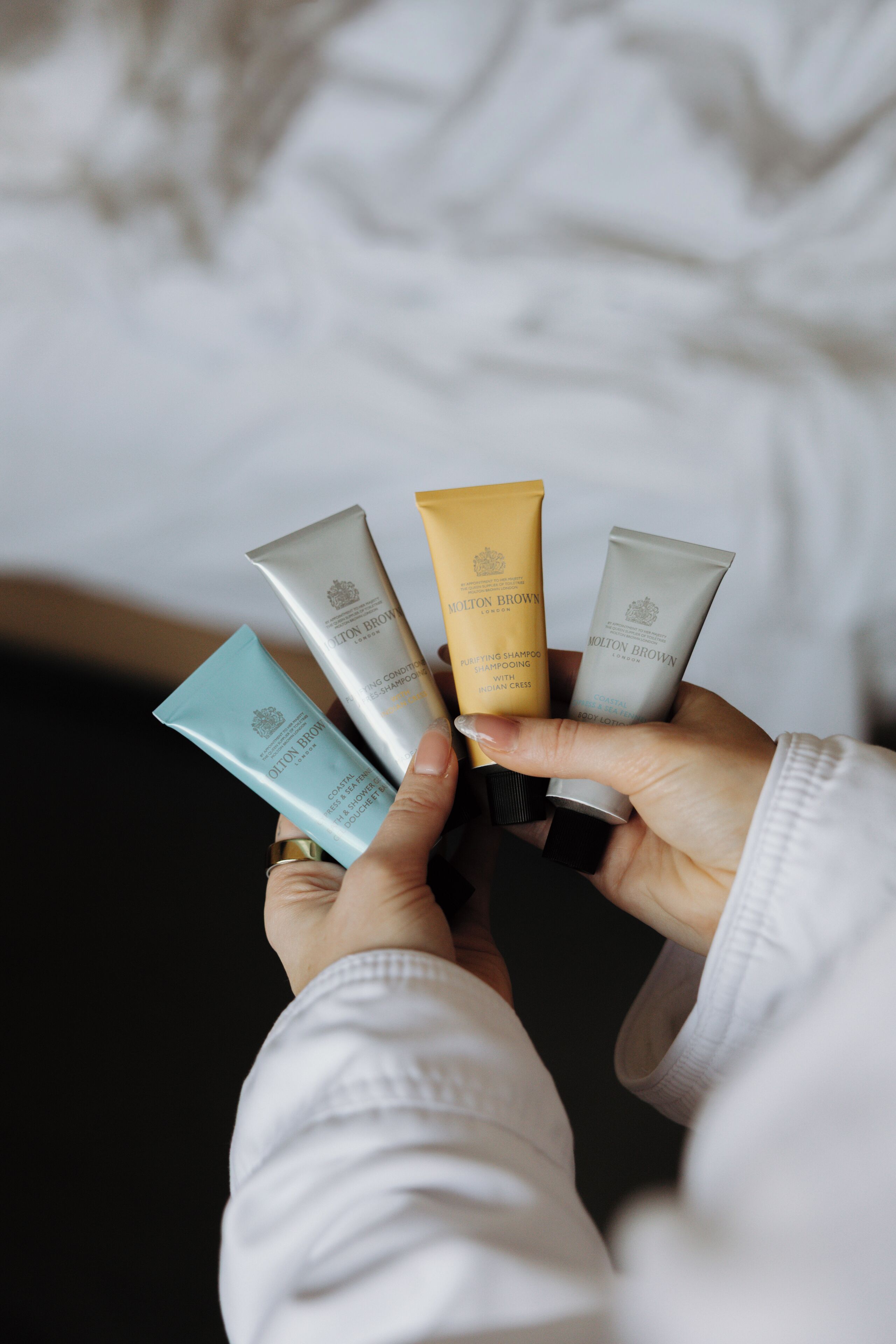 Uma pessoa segurando quatro produtos para cabelo.
