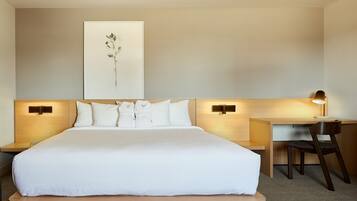 Una habitación de hotel con una cama grande, un escritorio y una silla.