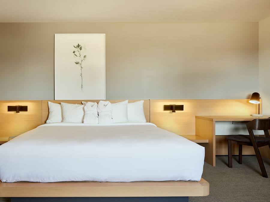 Una habitación de hotel con una cama grande, un escritorio y una silla.