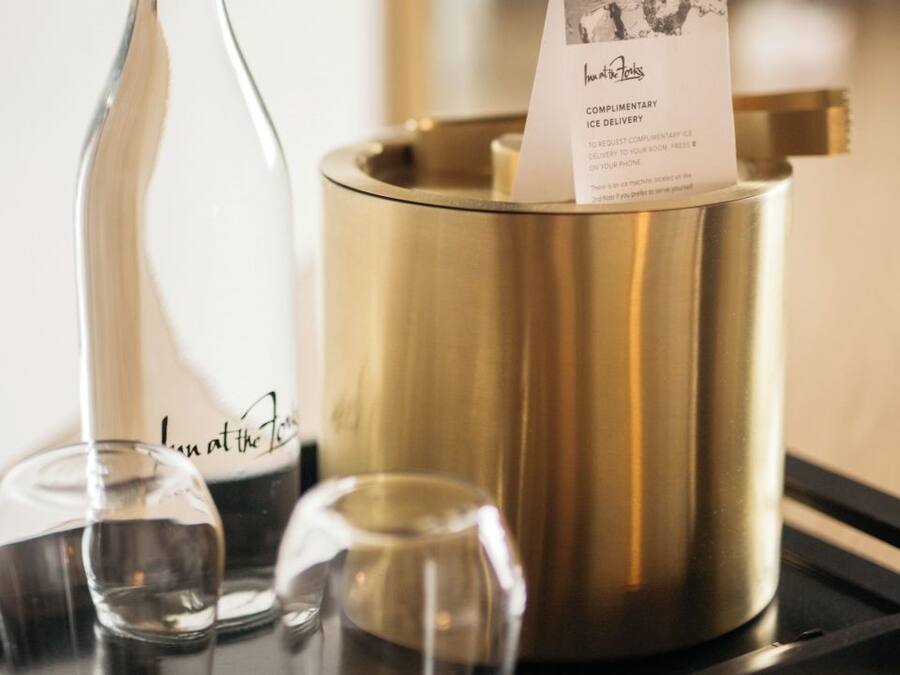 A tray with a glass bottle, a gold-colored container, and a card with text.