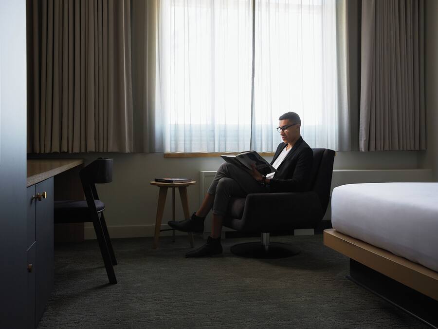 Una habitación de hotel con cama, escritorio y silla.