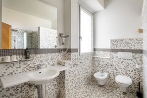 A bathroom with a sink, mirror, toilet, and bidet. - B&B Hotel Modena (Modena)