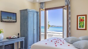 Hotelkamer met een bed, een bureau, een kledingkast en uitzicht op de oceaan.