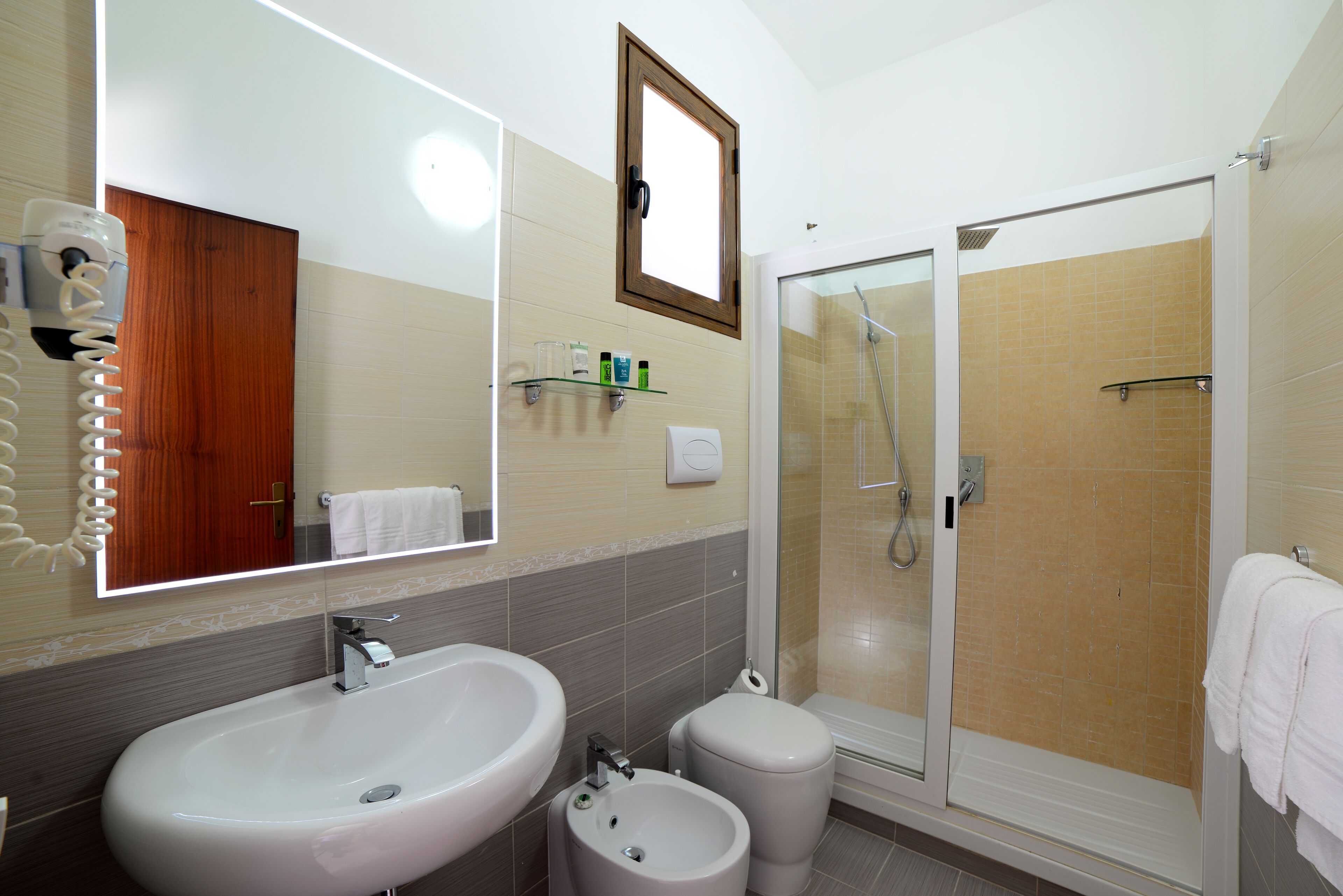 A bathroom with a large sink, a toilet, and a glass-enclosed shower.