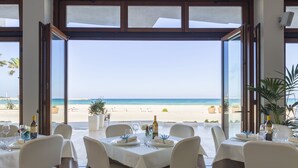Een eetgedeelte met een tafel voor zes personen, met uitzicht op een strand.