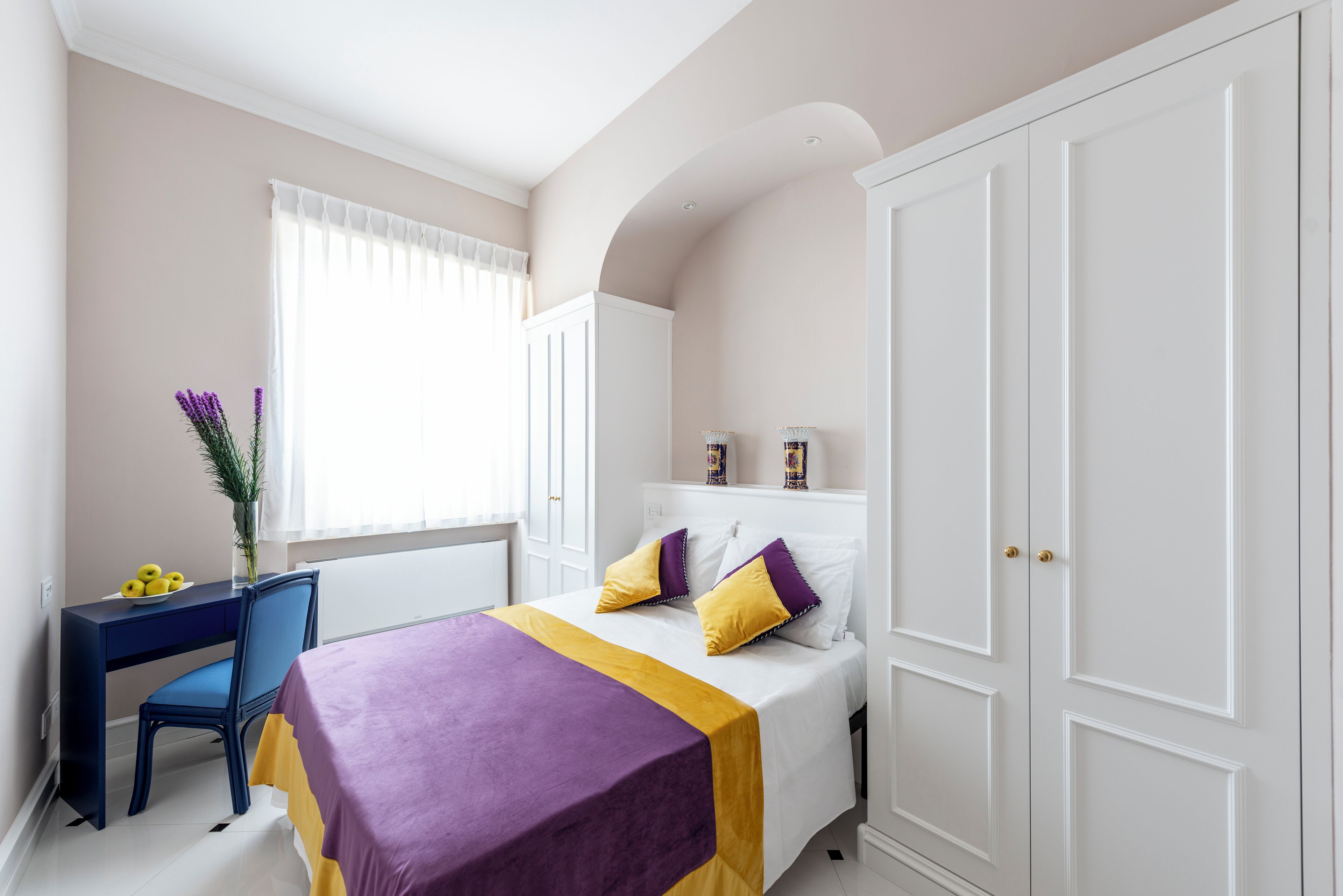 Un dormitorio con cama, escritorio y armario.