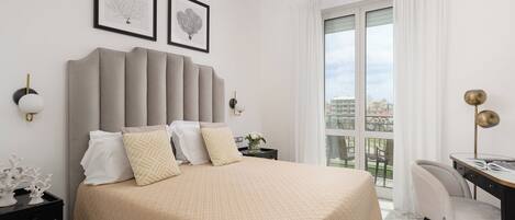 A modern bedroom with a large bed, a desk, and a view of the city.