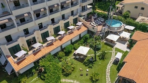 A multi-story hotel with balconies, a swimming pool, and outdoor seating areas. - Hotel Acapulco (Forte dei Marmi)