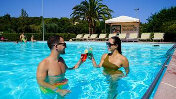 Una piscina al aire libre de temporada, sombrillas