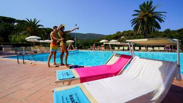 A poolside area with lounge chairs, umbrellas, and a clear view of the pool.