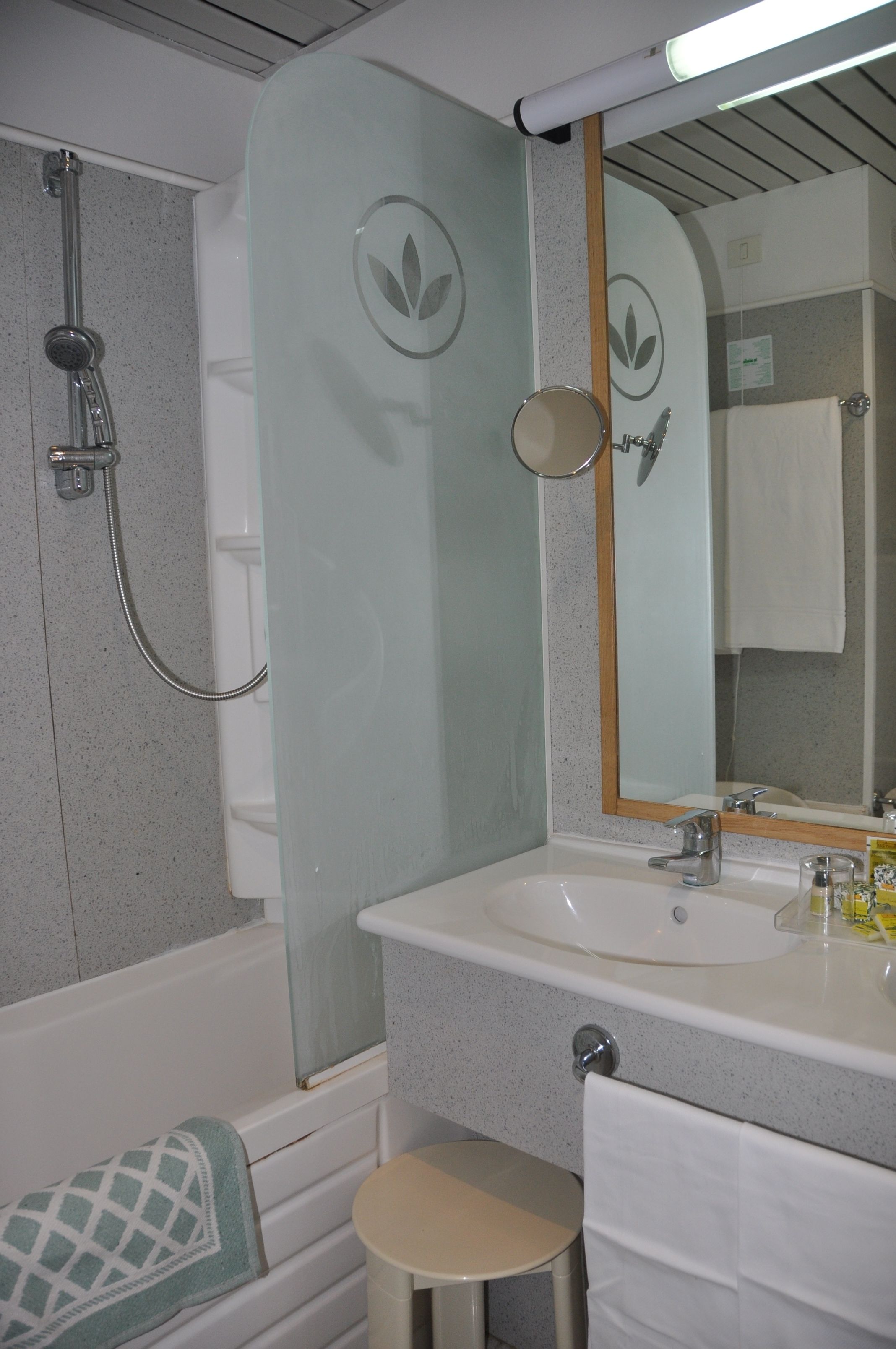 A bathroom with a bathtub, a sink, and a mirror.
