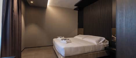 Ein modernes Schlafzimmer mit Bett, Vorhängen und Nachttisch.