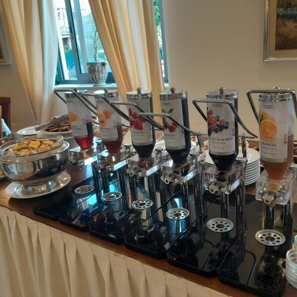 A buffet setup with various food dispensers labeled with different types of spreads and condiments.