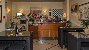 A bar area with a checkered wall, bar counter, and seating. - Hotel Villa Ombrosa (Pietrasanta)