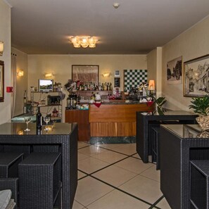 A bar area with a checkered wall, bar counter, and seating. - Hotel Villa Ombrosa (Pietrasanta)