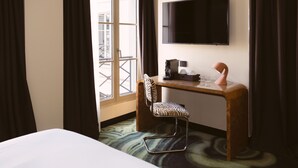 A hotel room with a bed, a desk with a chair, a flat-screen TV, and a window with curtains. - 1K Paris (Paris)