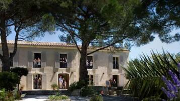 Un bâtiment doté d’un toit recouvert de tuiles, de nombreuses fenêtres et d’une entrée centrale.