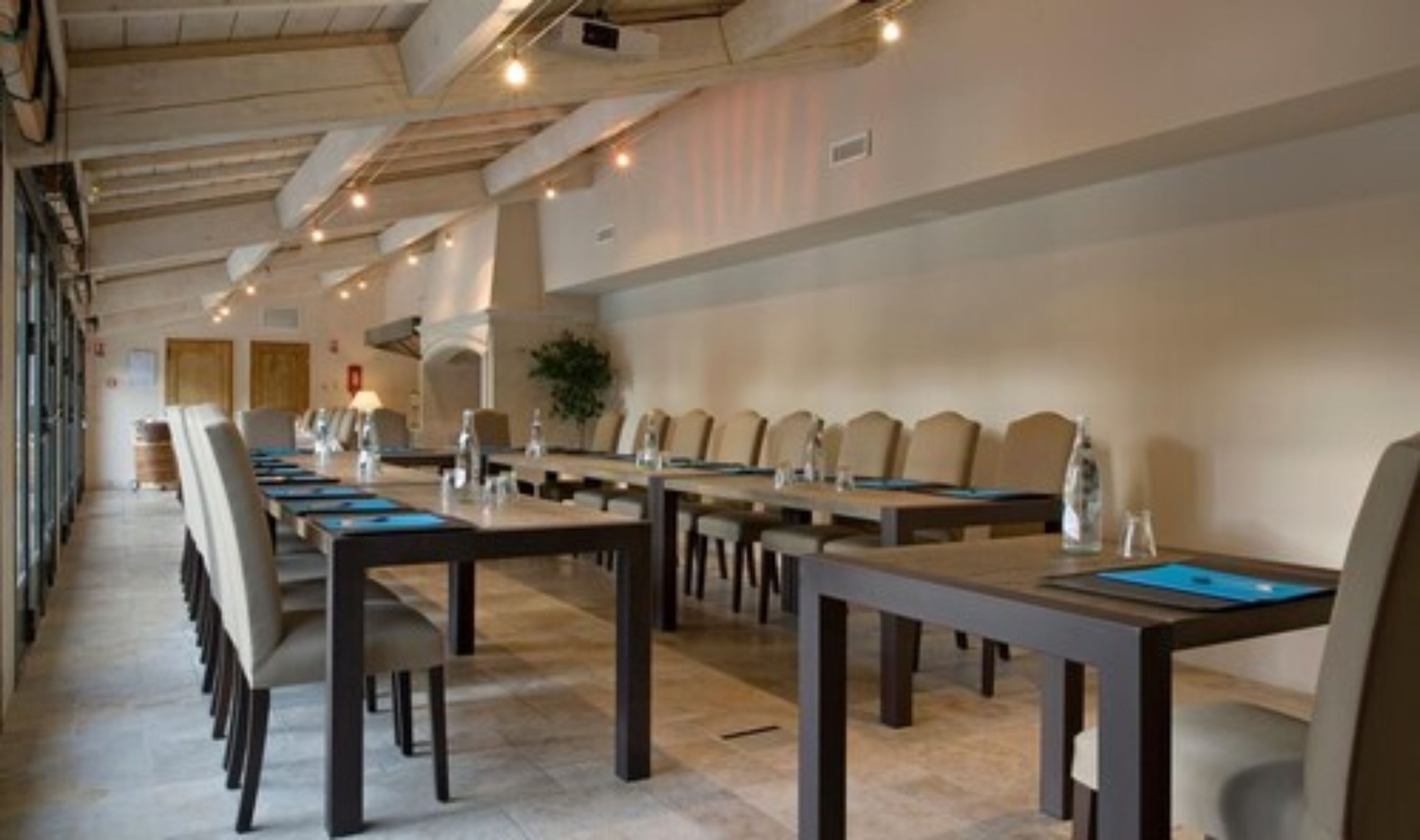 A conference room with long tables and chairs, equipped with water bottles and nameplates.