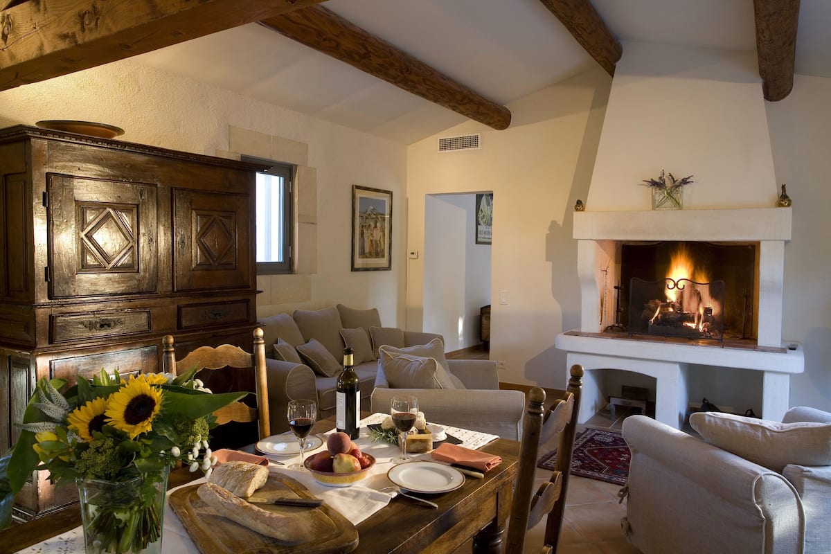 Un salon chaleureux avec une cheminée, des meubles en bois et une table à manger dressée avec de la nourriture et des boissons.