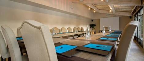 A conference room with a long table, chairs, and blue mats.
