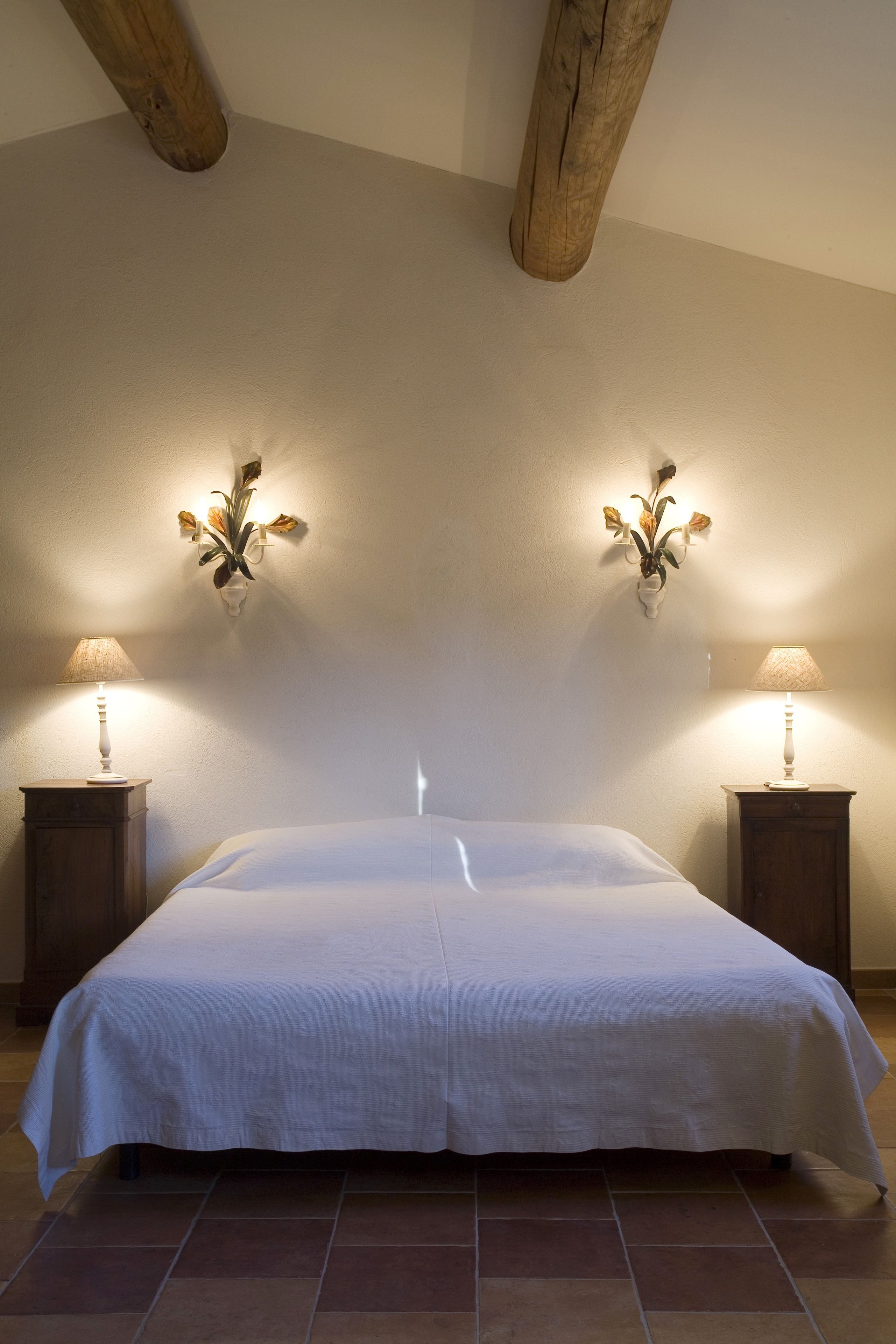 Ein Schlafzimmer mit einem großen Bett, zwei Nachttischen und Wandlampen.