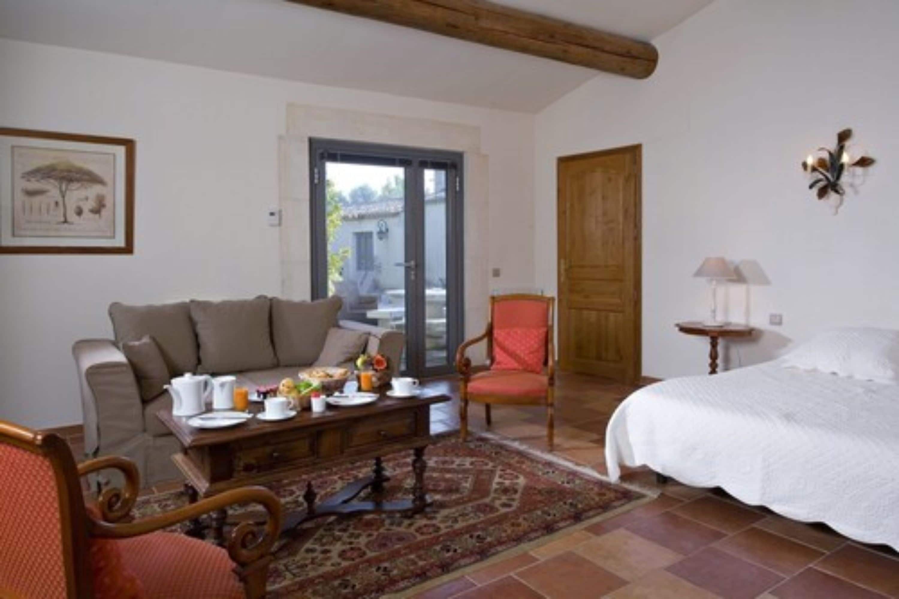 Una habitación acogedora con una cama, un sofá, una mesa de comedor y desayuno, y una silla.