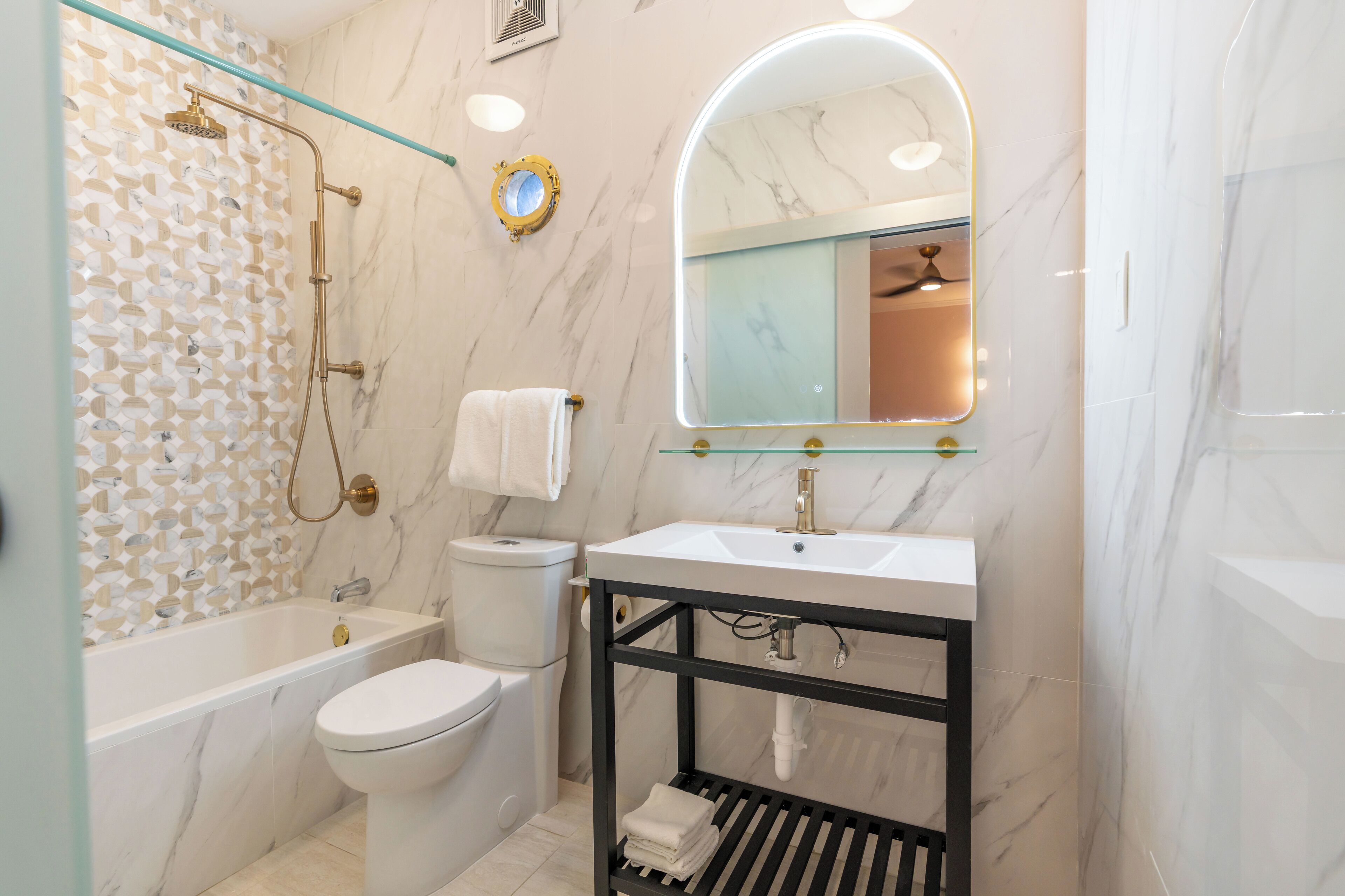 A modern bathroom with a bathtub, toilet, and sink.