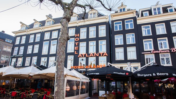 Un hôtel doté d’une terrasse et d’une enseigne indiquant « Hôtel Atlanta ».